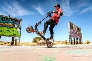 Un jeune homme démontre une performance d'un moteur de trottinette électrique en faisant une figure.