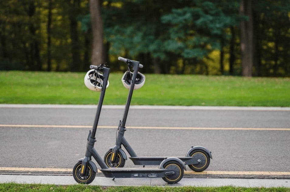 2 trottinettes sont présentées sur le bord de la route. Parmi les meilleures marques de pièces détachées pour trottinettes électriques, Xiaomi.