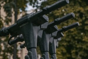 Plusieurs guidons de trottinettes sous la pluie. Quelle est la pièce de trottinette électrique la plus fragile ?