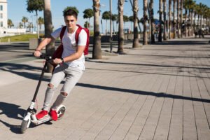 Une trottinette électrique circule à toute vitesse sur un trottoir, les freins trottinette électrique doivent être changés dès que possible.