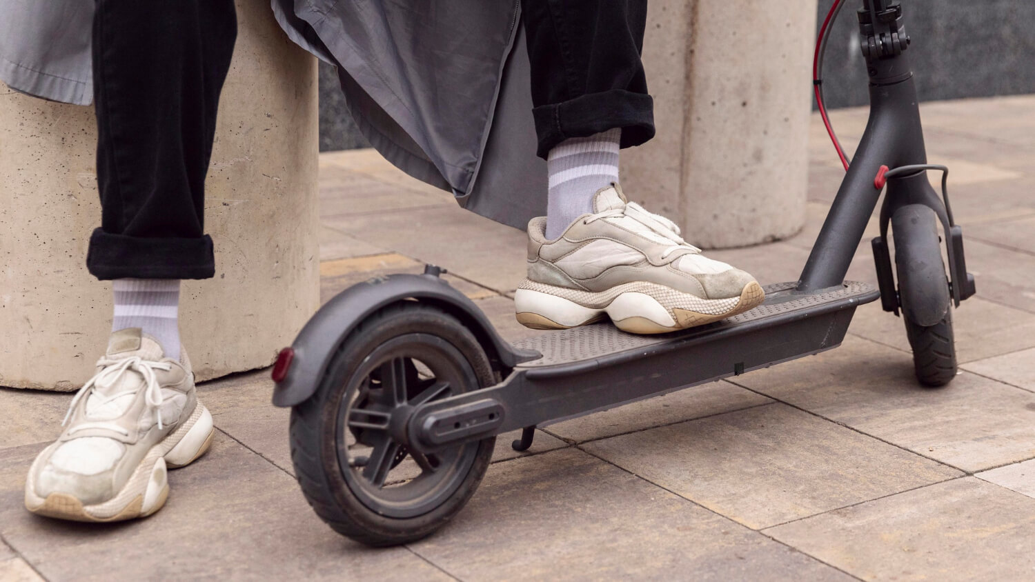 Une personne pose son pied sur une trottinette électrique munie d'une batterie sodium-ion. 